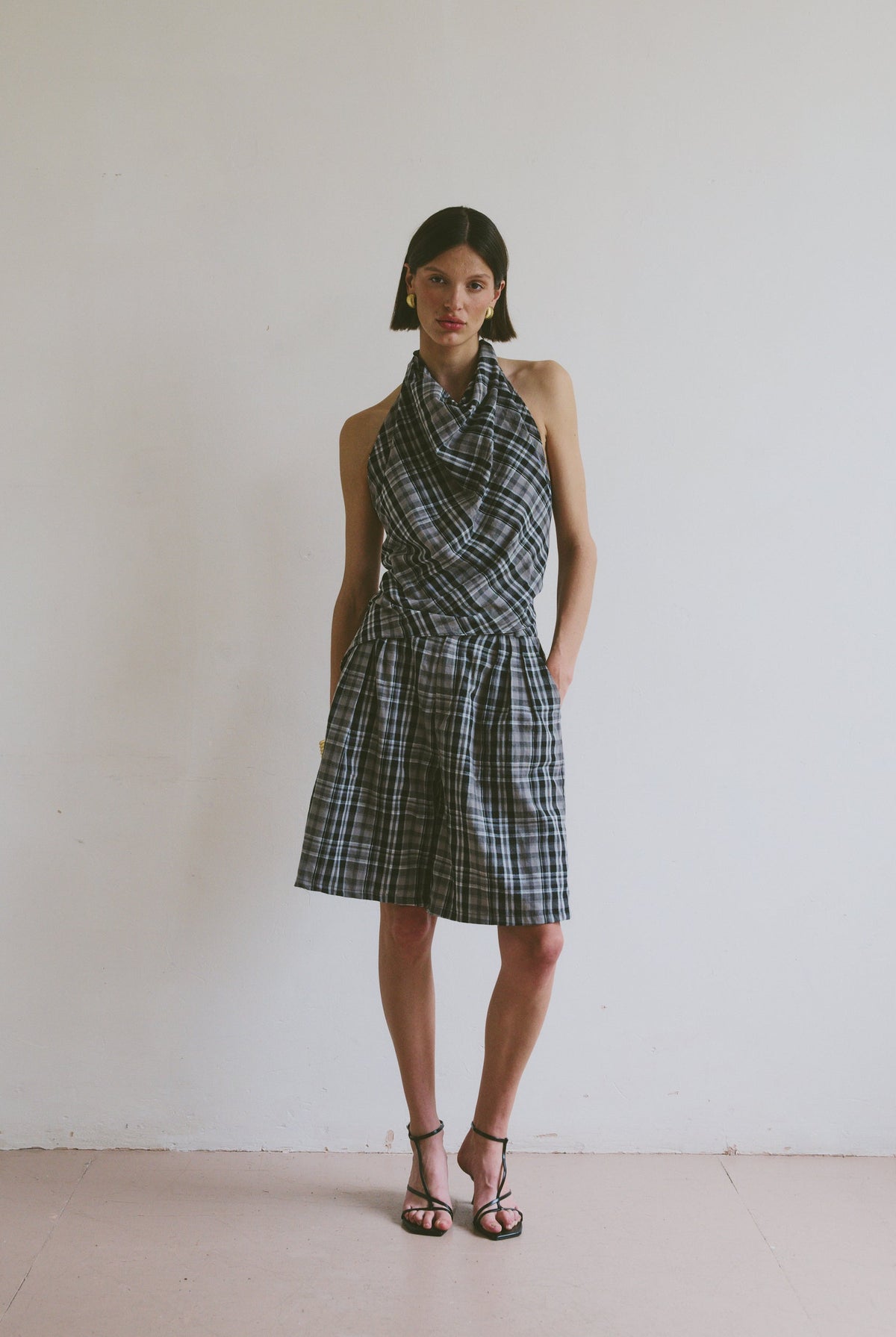 Model wearing a plaid set including a halter neck top and wide leg knee length shorts