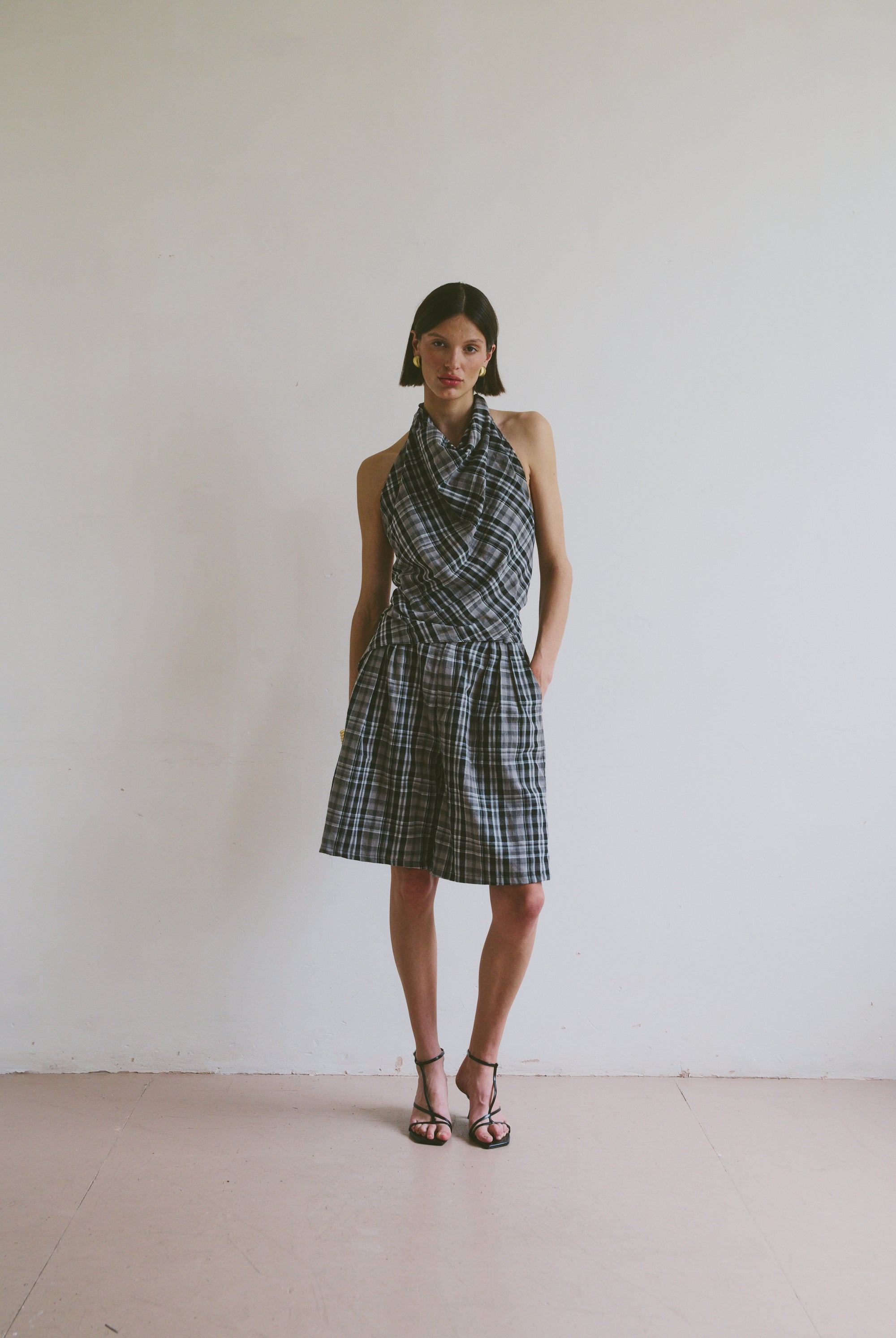 Model wearing a plaid set including a halter neck top and wide leg knee length shorts