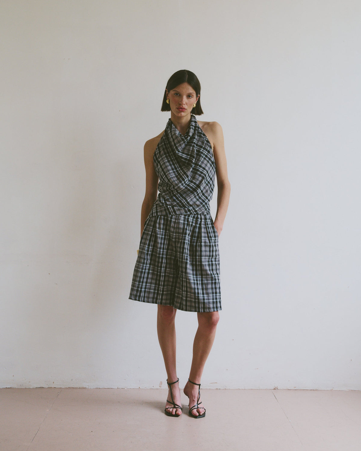 Model wearing a plaid set including a halter neck top and wide leg knee length shorts