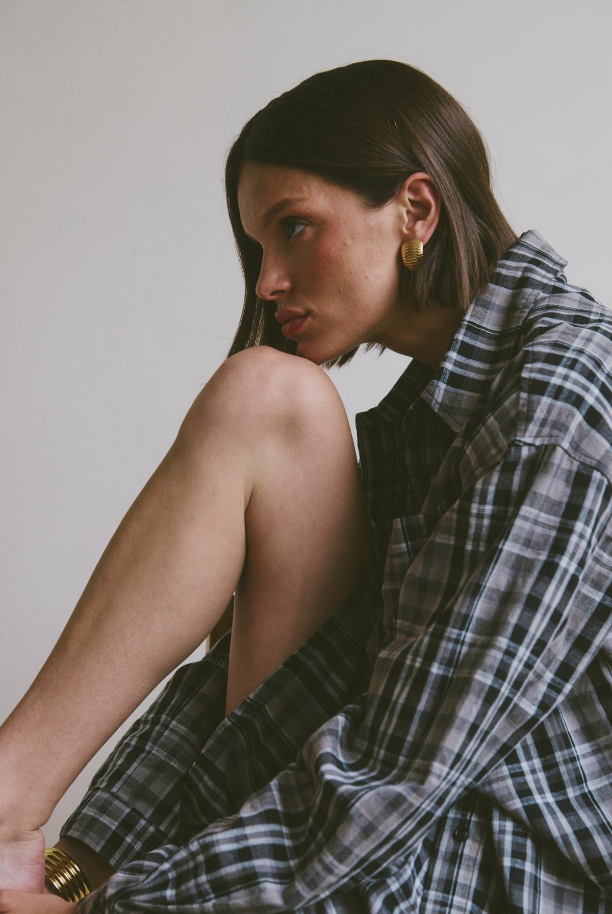Relaxed plaid shirt and shorts sitting against a plain background