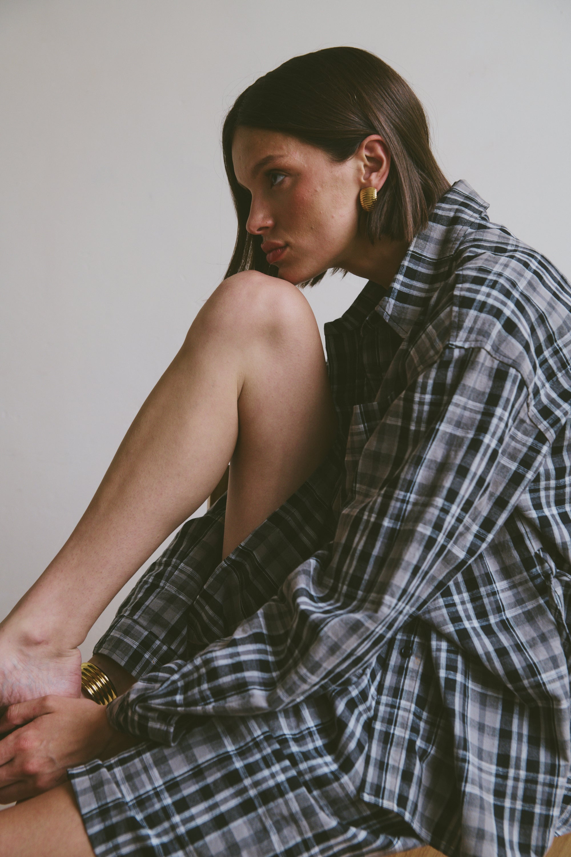Relaxed plaid shirt and shorts sitting against a plain background