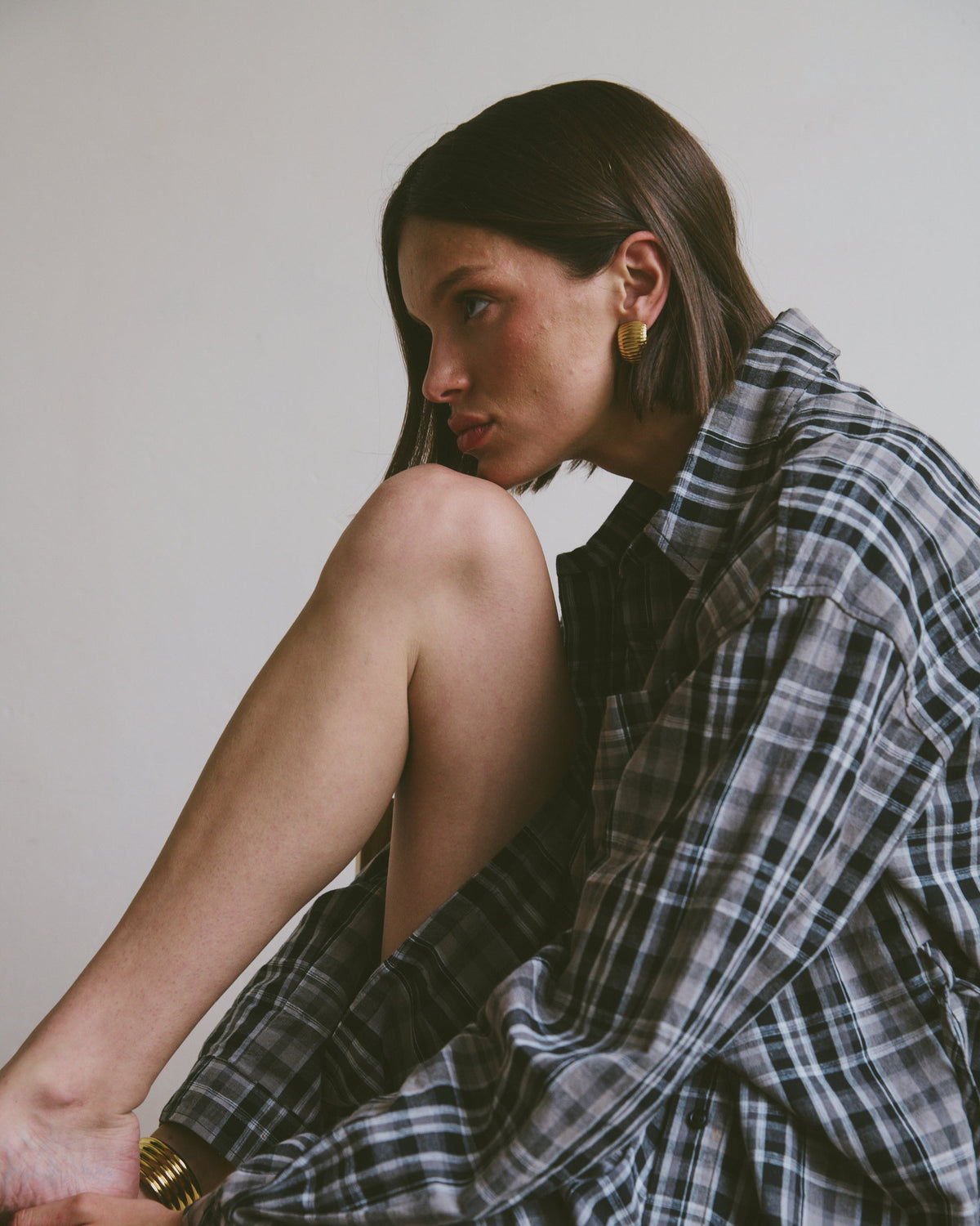 Relaxed plaid shirt and shorts sitting against a plain background