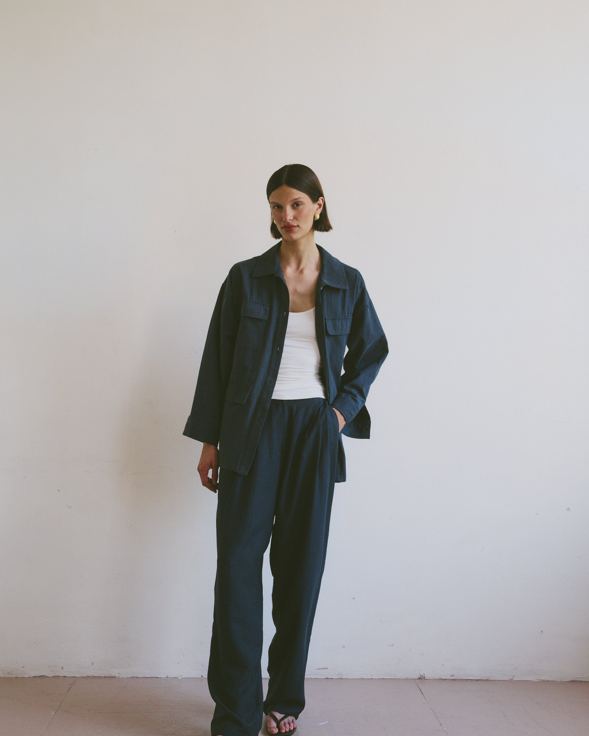 Model wearing a dark blue outfit against a plain white background