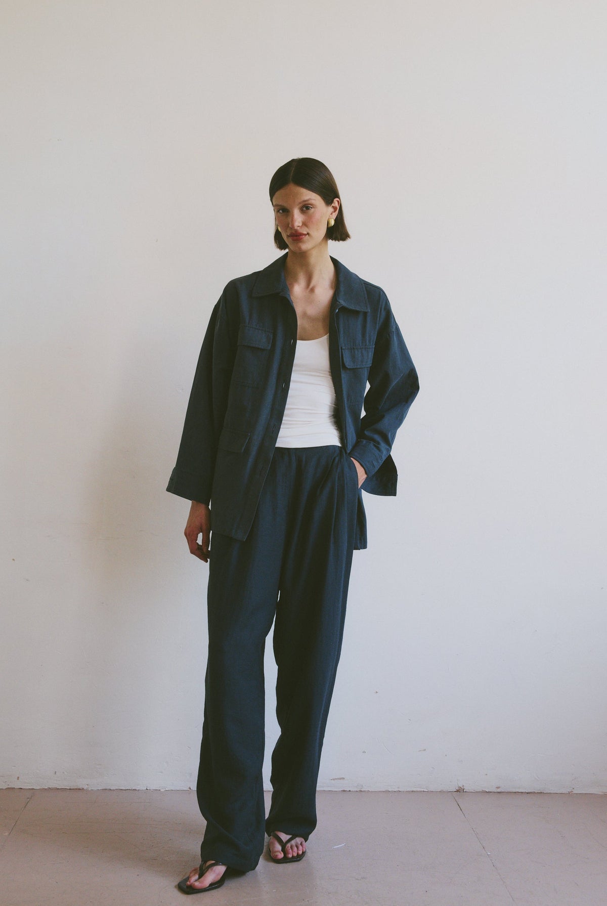 Model wearing a dark blue outfit against a plain white background