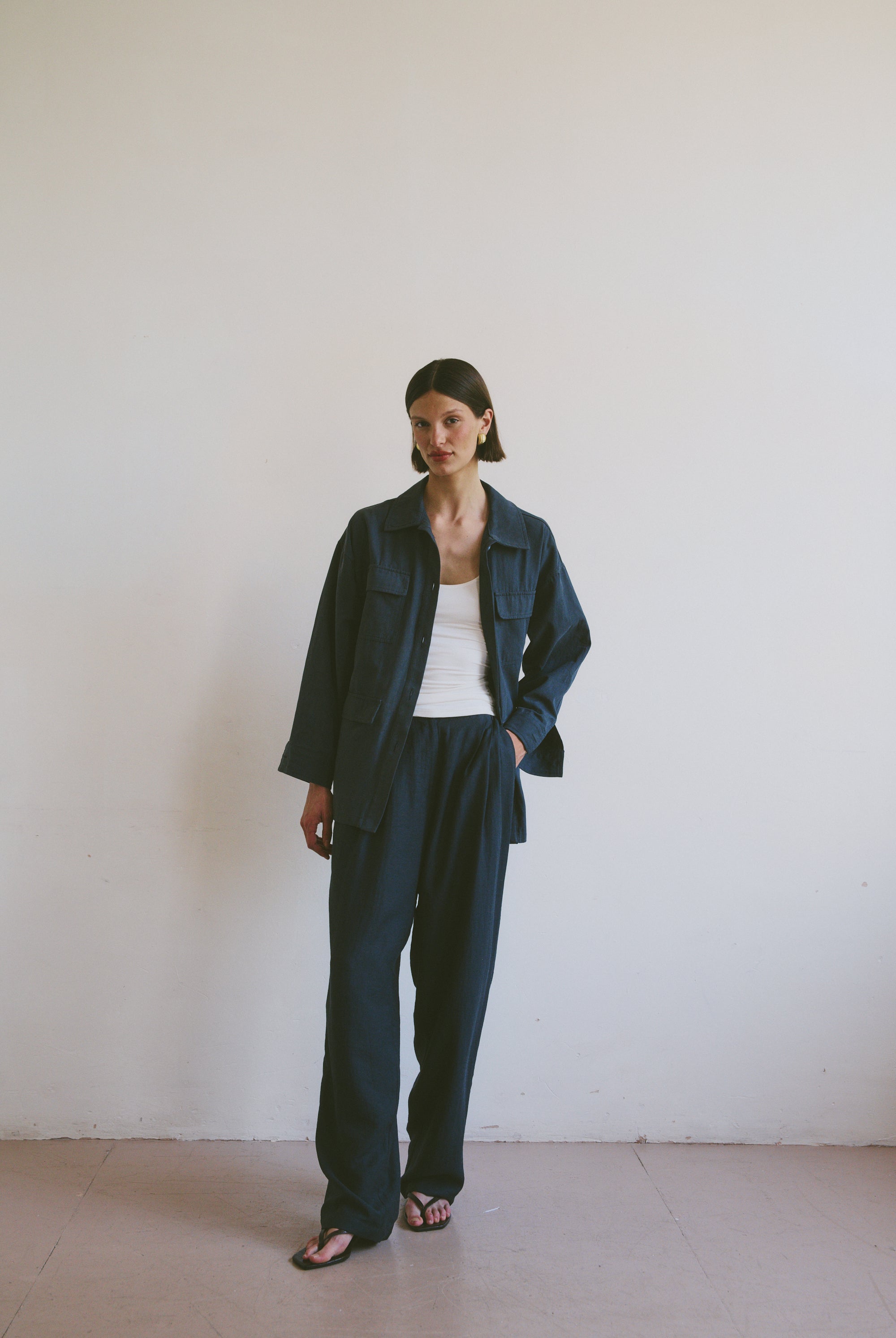 Model wearing a dark blue outfit against a plain white background