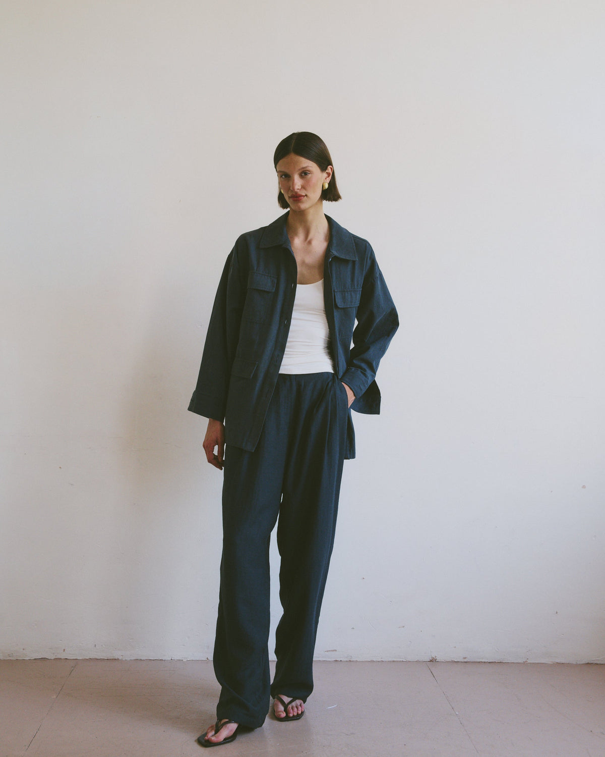 Model wearing a dark blue outfit against a plain white background
