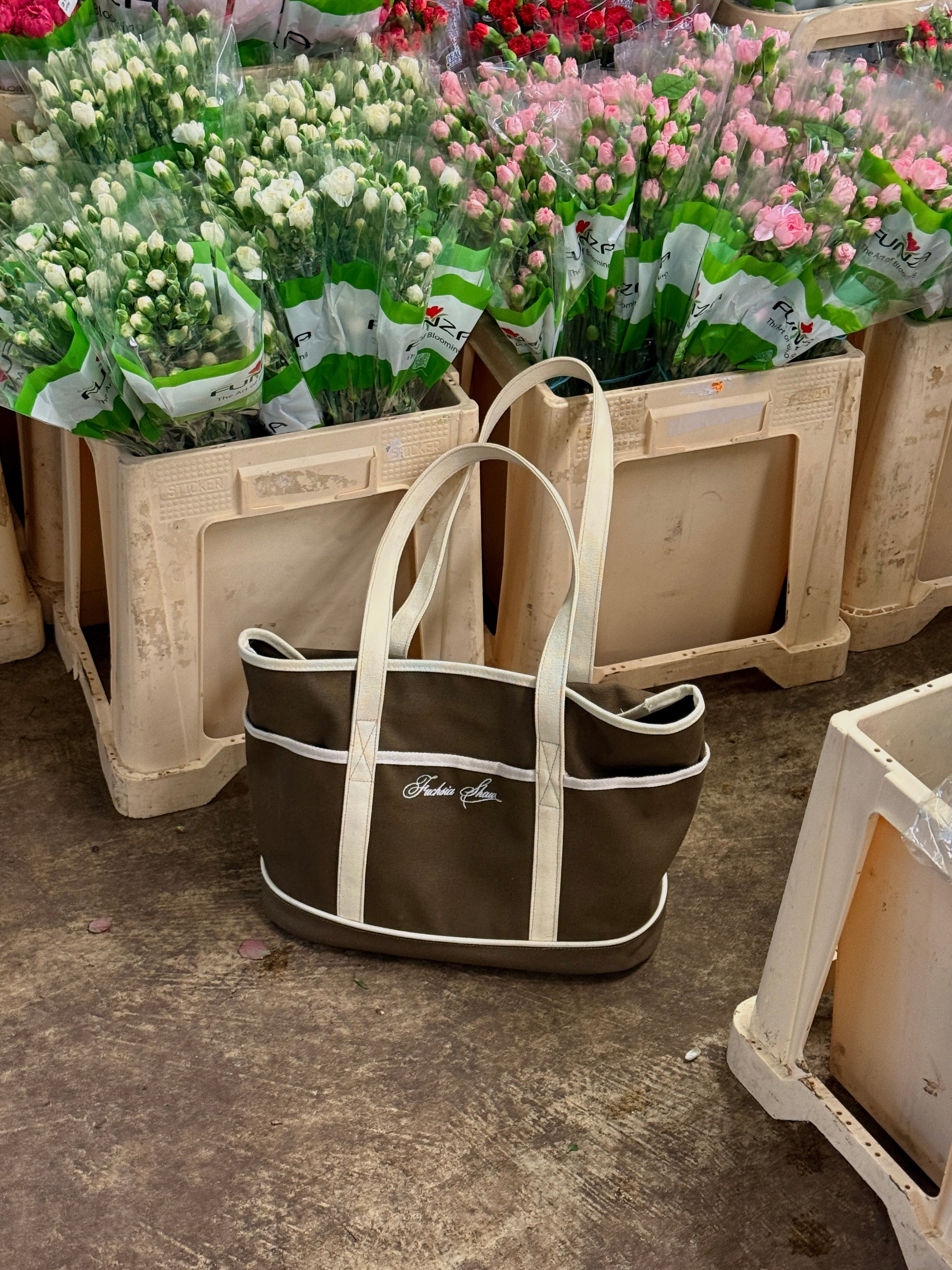 Brown tote with white details in a flower market
