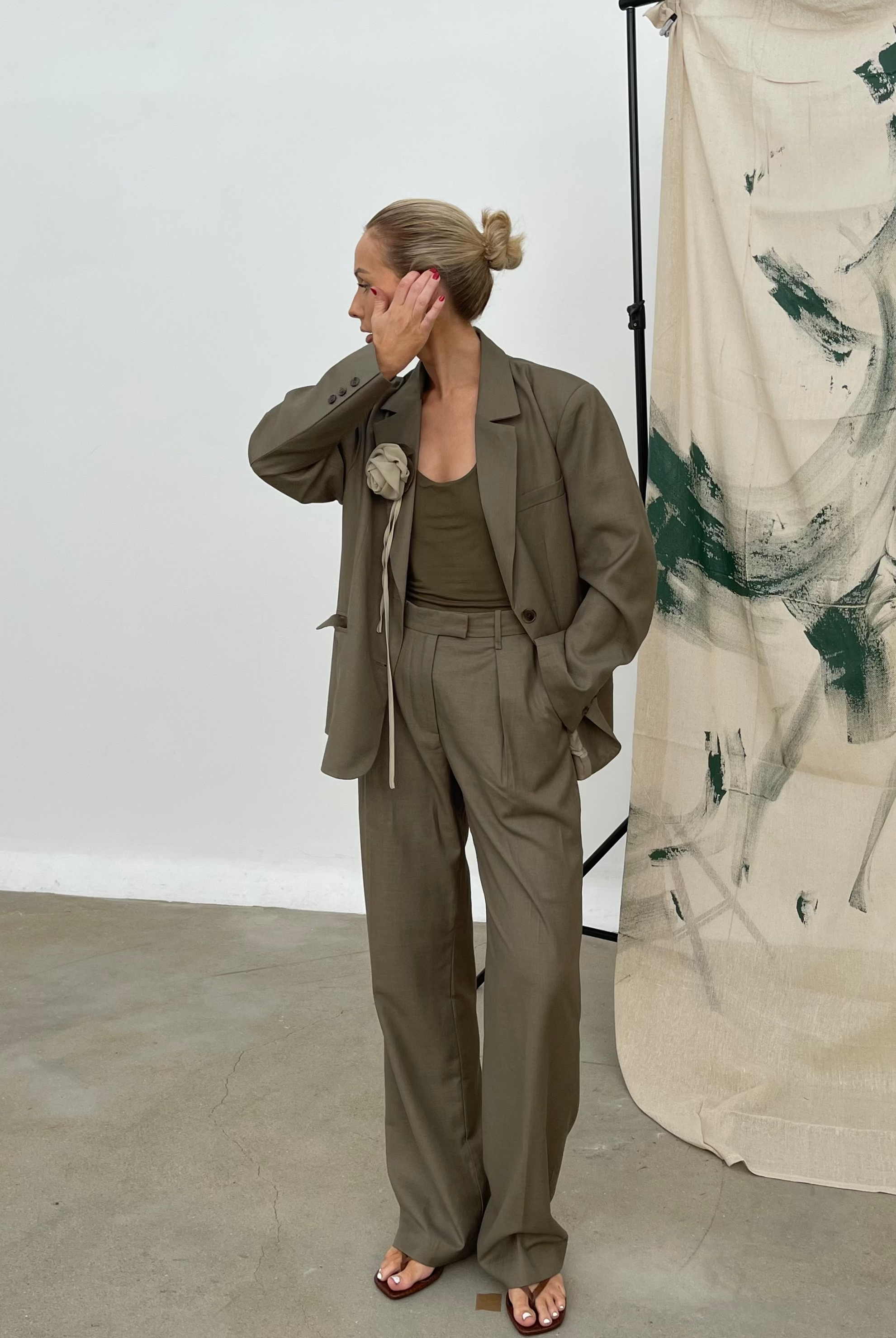 Model in studio wearing an oversized, relaxed fit soft olive Margaux blazer featuring notched lapels paired with matching wide-leg trousers and a tank