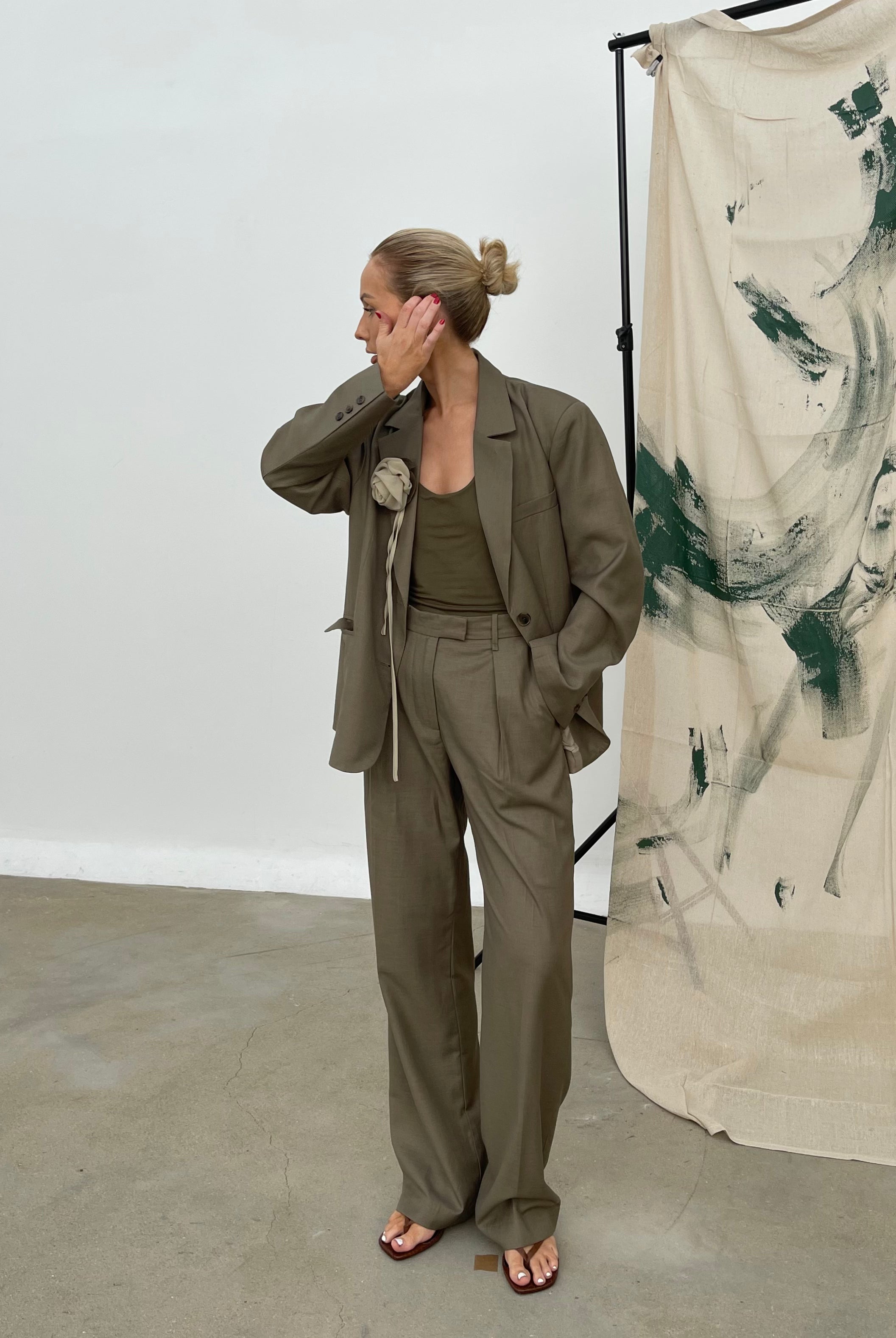 Model in studio wearing an oversized, relaxed fit soft olive Margaux blazer featuring notched lapels paired with matching wide-leg trousers and a tank