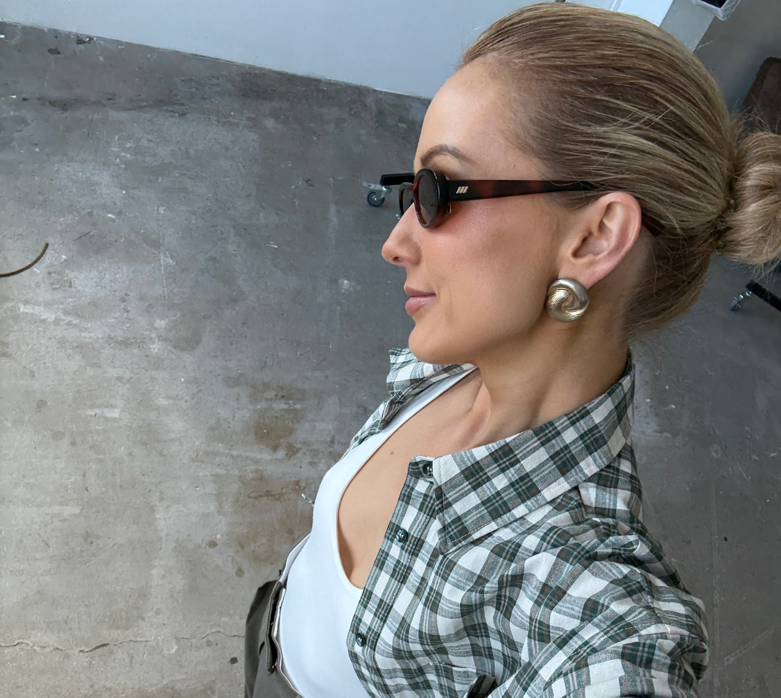 Person wearing a green and white checkered shirt on a concrete floor