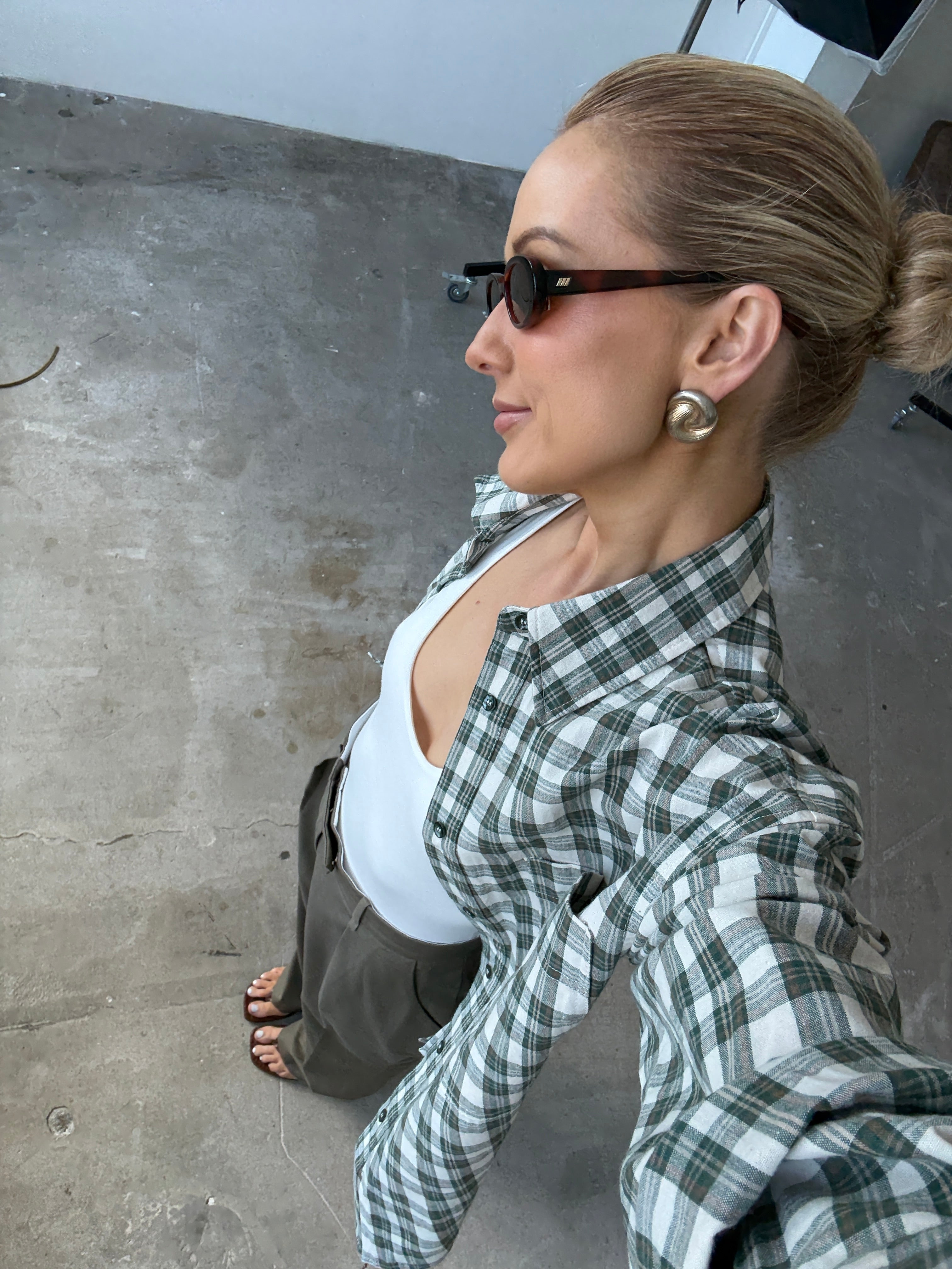 Person wearing a green and white checkered shirt on a concrete floor