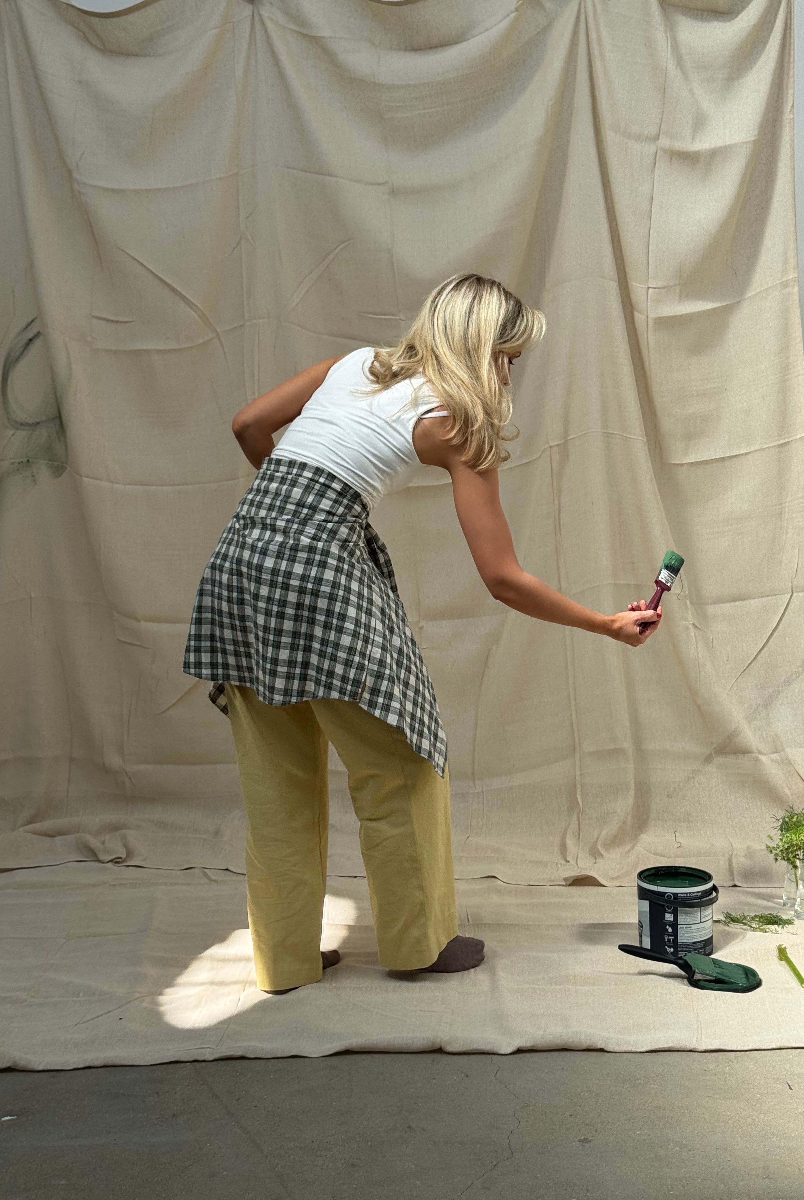 Person painting a large sheet with a brush