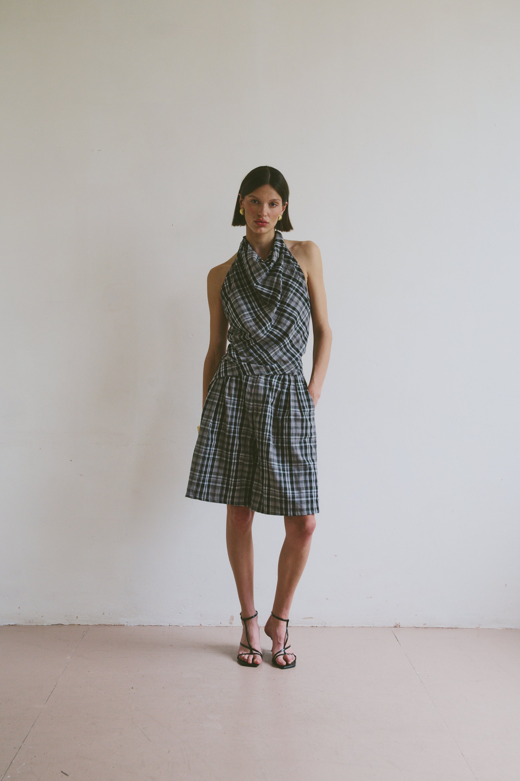 Model wearing a plaid set including a halter neck top and wide leg knee length shorts