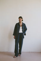 Model wearing a dark blue outfit against a plain white background