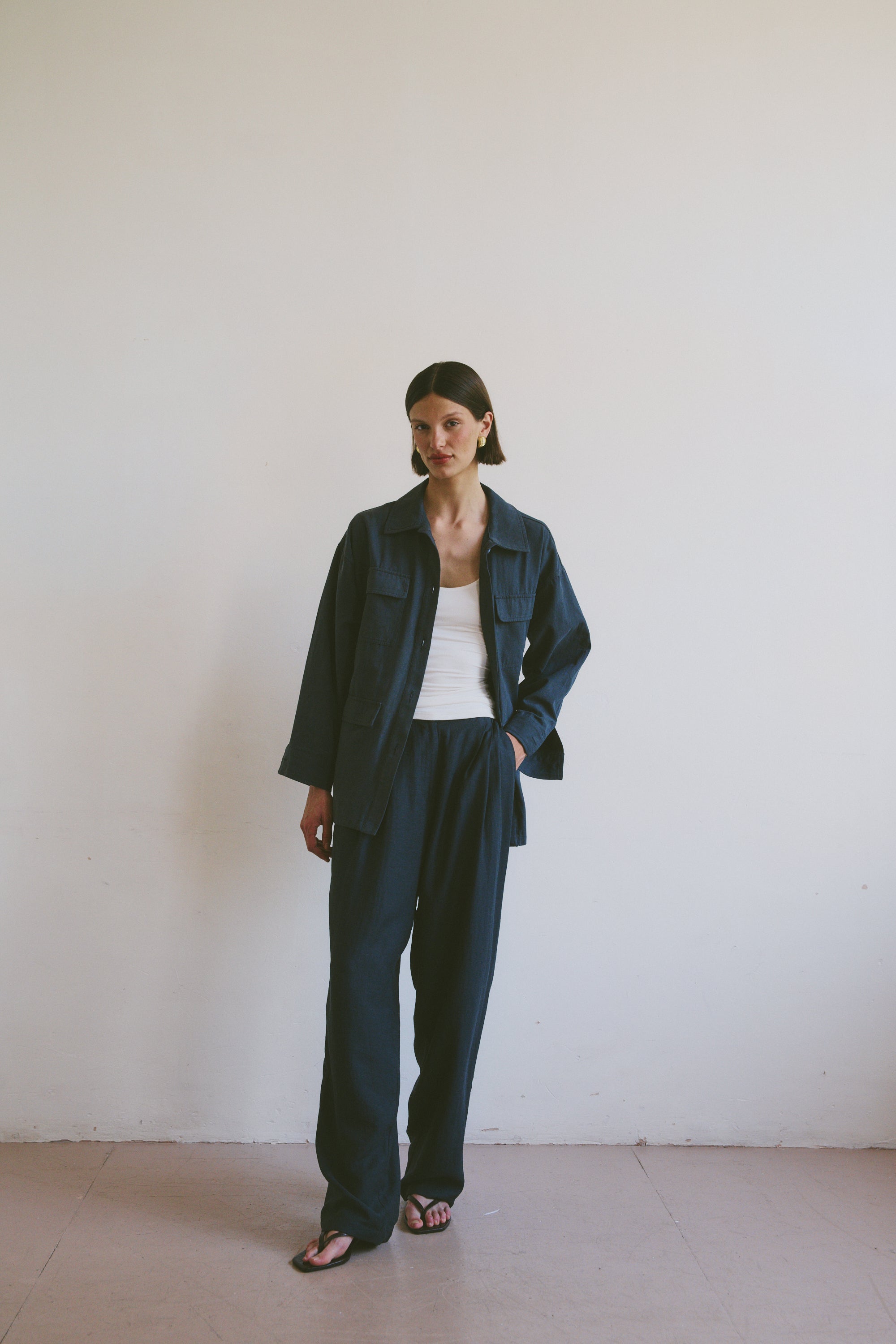 Model wearing a dark blue outfit against a plain white background