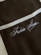 Close up of an embroidered white detail "Fuchsia Shaw"