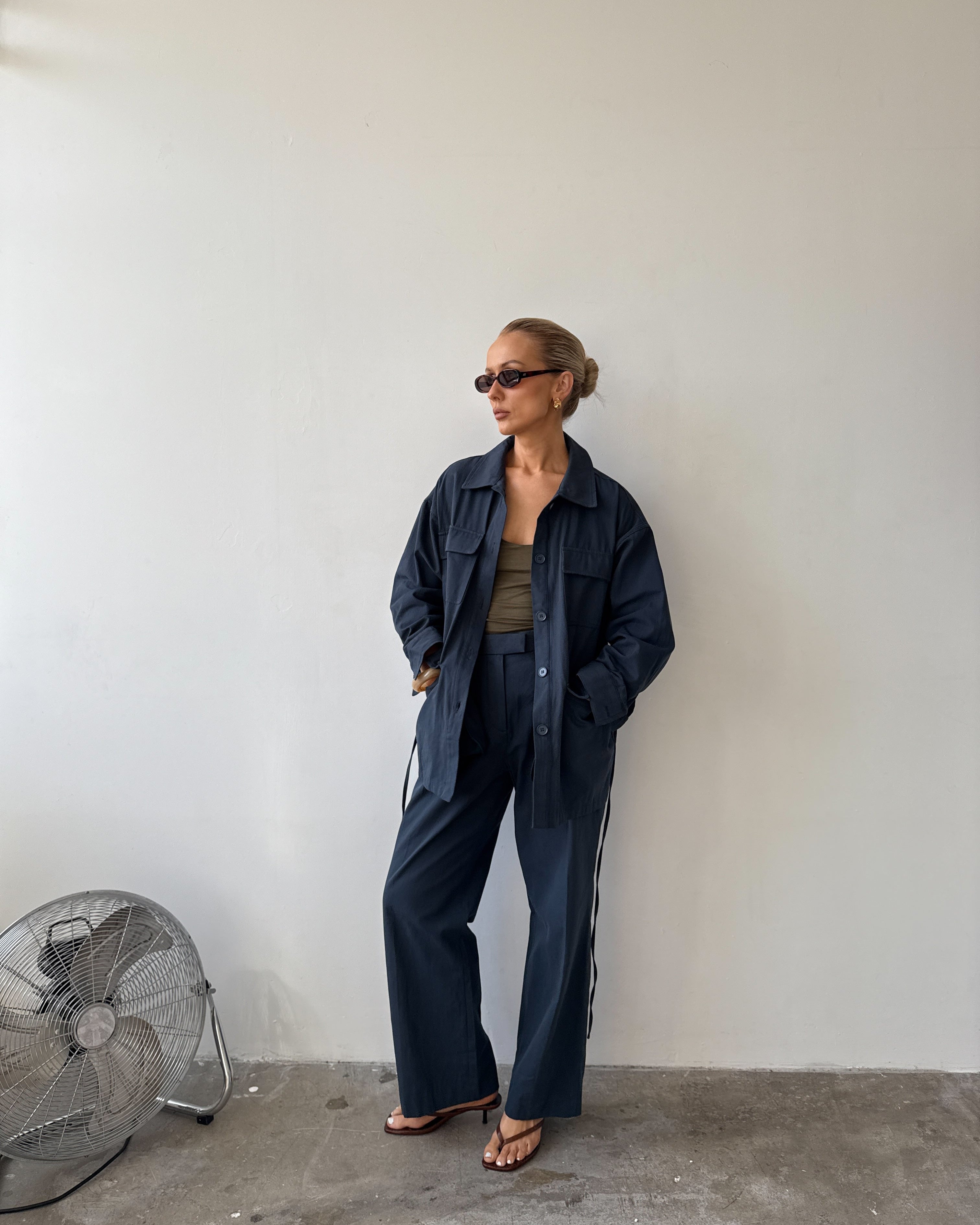 Model against a white background wearing a navy blue outfit 