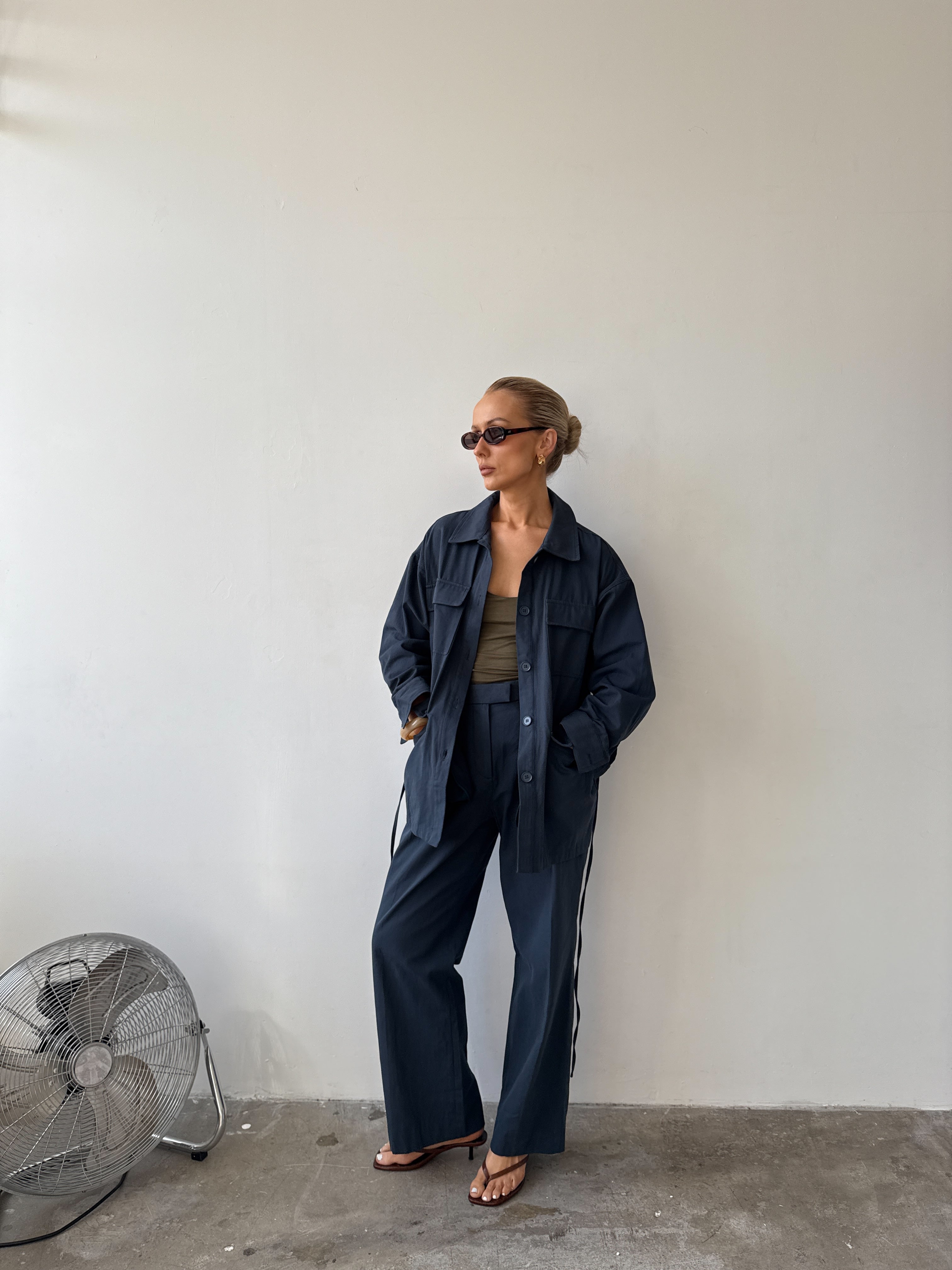 Model against a white background wearing a navy blue outfit 