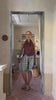 Model stands in a door frame while wearing a brown top and check shorts