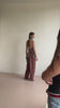 Several shots of a model posing in flowy red-brown trousers